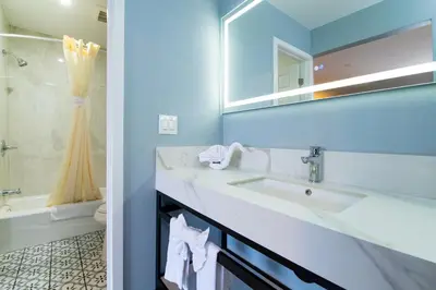 a bathroom with a sink and a mirror at Colonial Palace Inn in Downey