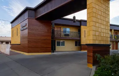 a large building with a balcony in a parking lot at Colonial Palace Inn in Downey
