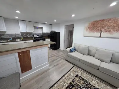 a living room with a couch and a kitchen at RGS cottage in Los Angeles in Los Angeles