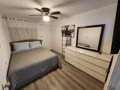 a bedroom with a bed and a dresser with a mirror at RGS cottage in Los Angeles in Los Angeles