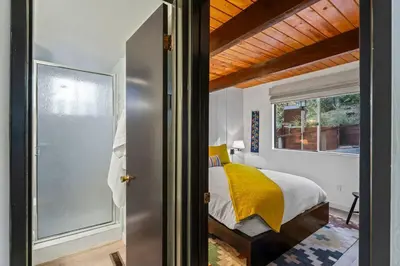 a bedroom with a bed with a yellow blanket at Fleming Creek Hideaway, Next to Creek, Fire-Pit! in Lake Arrowhead