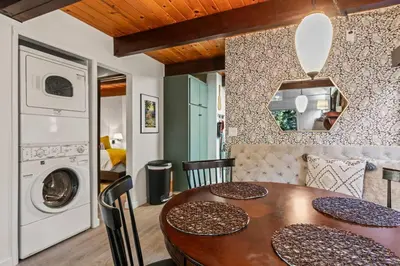 a dining room with a table and a washing machine at Fleming Creek Hideaway, Next to Creek, Fire-Pit! in Lake Arrowhead