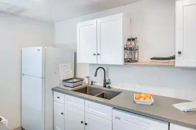 a kitchen with a sink and a white refrigerator at The Surf Retreat in Newbury Park