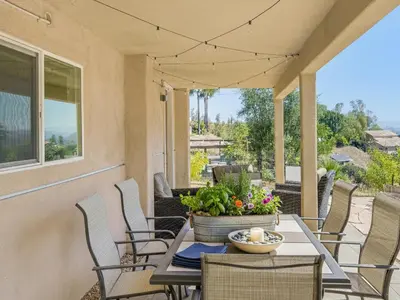 a porch with chairs and a table with a pot of flowers at The Surf Retreat in Newbury Park