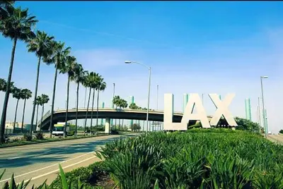 a large lax sign with palm trees on the side of a road at 22ppl Garage Parking Btw Disney Hollywood Monterey Park Chinatown in Monterey Park