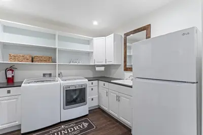 a kitchen with white cabinets and a refrigerator at Rocky Point Paradise Bay Lake Front Hot TUB 10 out of 10 in Lake Arrowhead