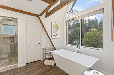 a bathroom with a large white tub and a window at Rocky Point Paradise Bay Lake Front Hot TUB 10 out of 10 in Lake Arrowhead