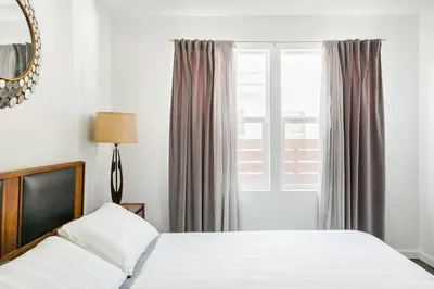 a bedroom with a white bed and a window at Perfect Venice Beach Vacation Home for Couples and Families in Los Angeles
