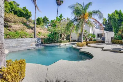 a swimming pool in a yard with palm trees at 3 Mi to Beach Home with Pool and Spa in Malibu! in Malibu