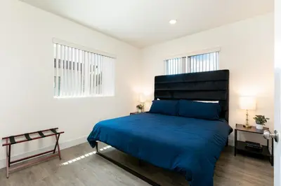 a bedroom with a blue bed and two windows at La Veranda View Hideaway in Los Angeles