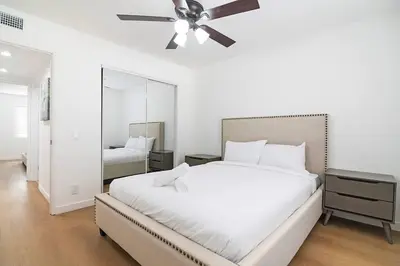 a bedroom with a large white bed with a ceiling fan at 2BR Plus Bonus Room and Pool Access Near Universal Studios in Los Angeles