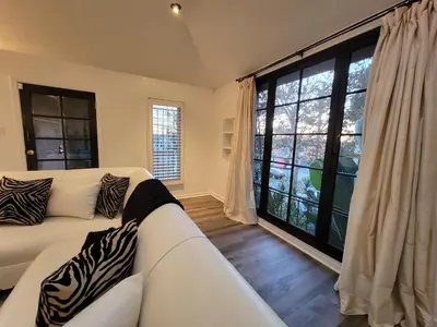 a living room with a white couch and a large window at 3 bedroom top story apartment near Pico blvd in Los Angeles