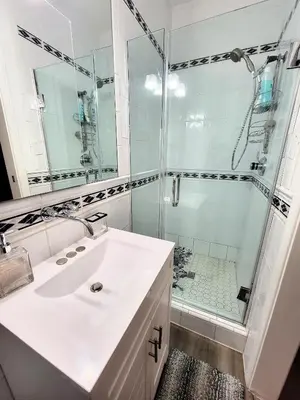 a white bathroom with a shower and a sink at 3 bedroom top story apartment near Pico blvd in Los Angeles