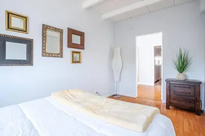 a white bedroom with a large bed and a table at Sunset Hilltop Flat in Los Angeles