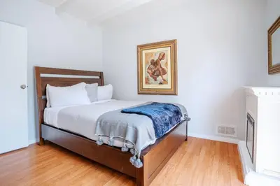 a bedroom with a bed with a picture on the wall at Sunset Hilltop Flat in Los Angeles