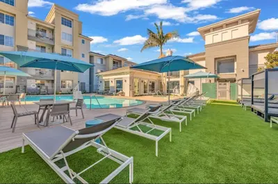 a group of chairs and umbrellas next to a pool at Loft Style,2 Beds ,Flexible self check in,Pool in Marina del Rey