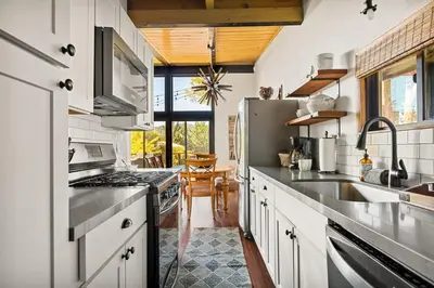 a kitchen with white cabinets and stainless steel appliances at YOLO Lake Escape in Big Bear Lake