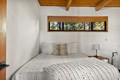 a bedroom with a white bed with a window at YOLO Lake Escape in Big Bear Lake