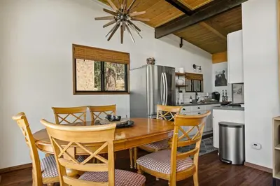 a kitchen with a table and chairs and a refrigerator at YOLO Lake Escape in Big Bear Lake