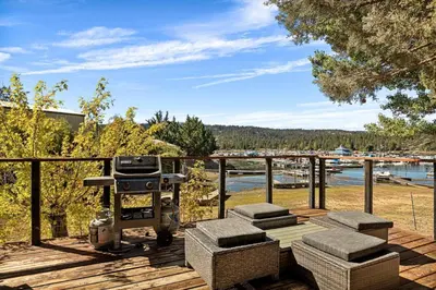 a grill on a deck with a view of the water at YOLO Lake Escape in Big Bear Lake