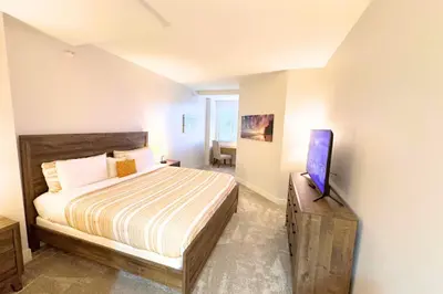 a bedroom with a bed and a flat screen tv at Cozy Apartment Homes On Wilshire Corridor in Los Angeles
