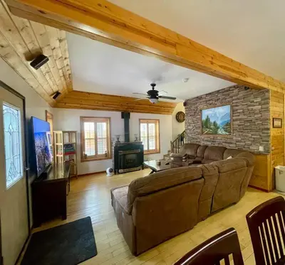 a living room with a couch and a brick wall at Cabin 7 sleeps 8 BEAUTIFUL BOULDER BAY, BIG BEAR in Big Bear Lake
