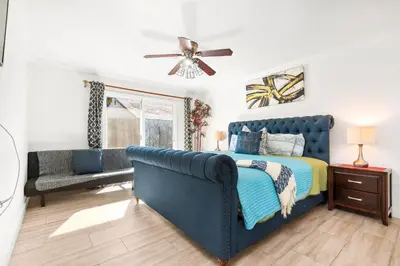 a bedroom with a blue bed and a couch at Gated 6beds 2garage home near Disney other LA attraction in Chino
