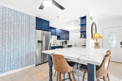 a kitchen with blue cabinets and a white table and chairs at Gated 6beds 2garage home near Disney other LA attraction in Chino