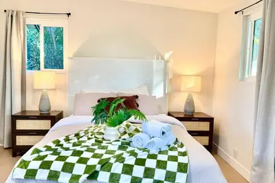 a bedroom with a bed with a green and white checkered blanket at Jies choice Contemporary Elegance in Altadena in Altadena