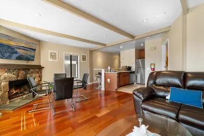 a living room with a leather couch and a fireplace at Lakeview Condo - Lakefront Complex, Lake Views, Heated Pool in Big Bear Lake