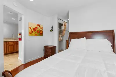 a bedroom with a large white bed and a kitchen at Lakeview Condo - Lakefront Complex, Lake Views, Heated Pool in Big Bear Lake