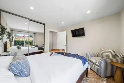 a bedroom with a bed and a tv and a chair at Resort Home with Games, Slide, Oasis in Los Angeles
