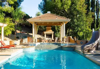 a swimming pool with a gazebo next to a swimming pool at Resort Home with Games, Slide, Oasis in Los Angeles