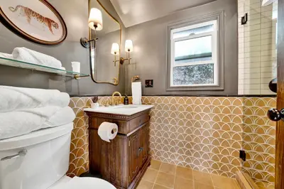 a bathroom with a toilet and a sink and a mirror at Villa Encanto- LUXE Spanish Villa with 6 KING Bedrooms, Courtyard and New Game Room in Long Beach