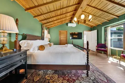 a bedroom with a large bed and green walls at Villa Encanto- LUXE Spanish Villa with 6 KING Bedrooms, Courtyard and New Game Room in Long Beach