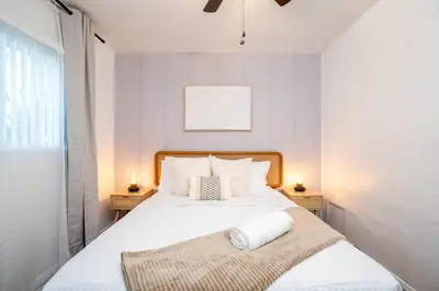 a bedroom with a large white bed with two night stands at Stylish Cozy, Aesthetic, Stocked Kitchen, and Pet Friendly in Palmdale