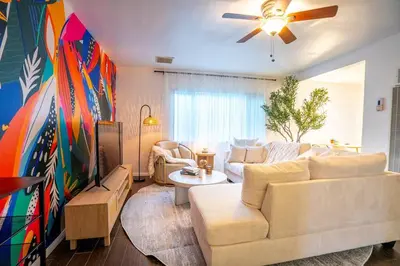 a living room with a white couch and a tv at Stylish Cozy, Aesthetic, Stocked Kitchen, and Pet Friendly in Palmdale