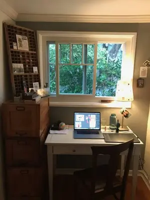 a desk with a laptop computer on it in front of a window at Beautifully Restored Pasadena English Cottage in Pasadena