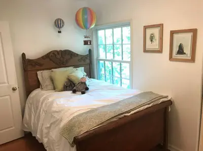 a teddy bear sitting on a bed in a bedroom at Beautifully Restored Pasadena English Cottage in Pasadena