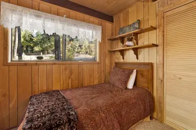 a bedroom with a bed in a wooden room at Mountain Hideaway on Maryland #2494 in Big Bear Lake