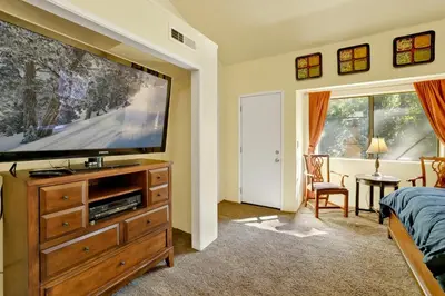 a bedroom with a large flat screen tv on a wooden dresser at Buttercup #2508 in Big Bear Lake