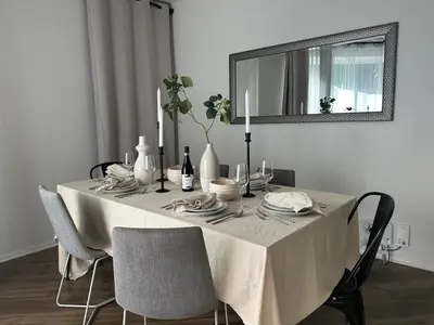 a dining room table with a white table cloth and a mirror at Beautiful Getaway Near Venice in Los Angeles
