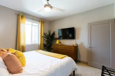 a bedroom with a bed and a tv on the wall at 3 Miles to Disney Heated Pool CnvntnCtr Jacuzzi in Fullerton