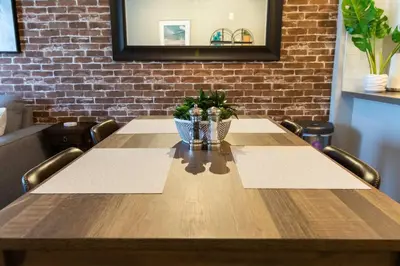 a wooden table in a room with a brick wall at 3 Miles to Disney Heated Pool CnvntnCtr Jacuzzi in Fullerton