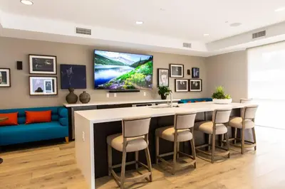 a kitchen with a bar with a tv on the wall at 3 Miles to Disney Heated Pool CnvntnCtr Jacuzzi in Fullerton