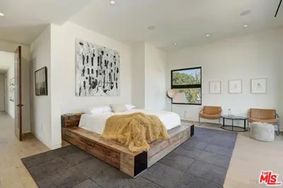 a bedroom with a large bed with a blanket on it at Sycamore Ave in Los Angeles