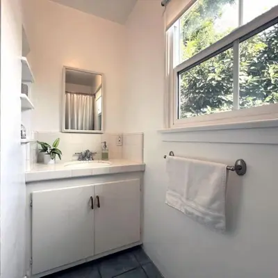 a bathroom with a sink and a mirror and a window at The Culver Retreat Family Oasis w Office Backyard in Los Angeles
