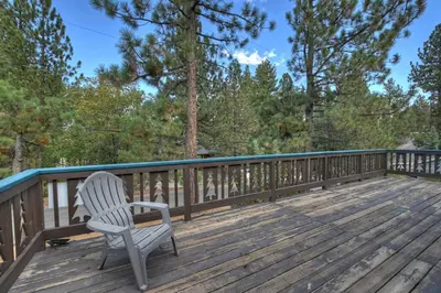 a white chair sitting on a wooden deck at Village Hideaway walking to the village in Big Bear Lake