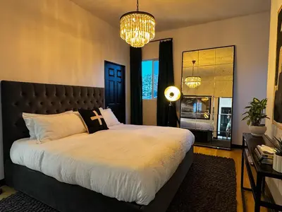 a bedroom with a large bed and a chandelier at The Loft at Butler in Los Angeles