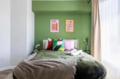 a green bedroom with a large bed with colorful pillows at Cozy 2BD Retreat in MarinaDelRey!Free Parking&Pool in Los Angeles